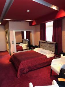 una camera d'albergo con un grande letto e uno specchio di Grand Hotel Petrol a Fier