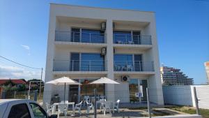 a building with tables and umbrellas in front of it at Waterman in Costinesti