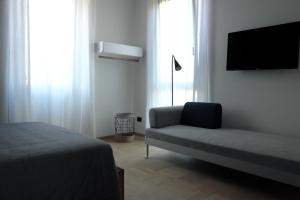 a bedroom with a bed and a couch and a tv at INVENTO bnb unconventional maison in Civitanova Marche