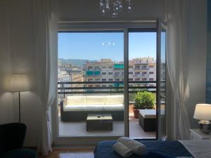 een slaapkamer met een grote glazen deur naar een balkon bij Mareluna Penthouse - Luxury Suites in Salerno