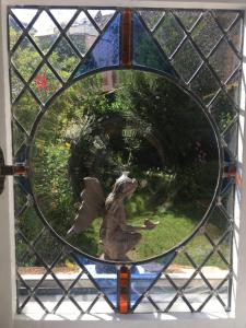 a glass window with a reflection of a garden at Jardin Secret in Moulins