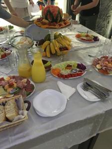 una mesa cubierta con platos de comida y fruta en Prenociste Bojan 017, en Vranje