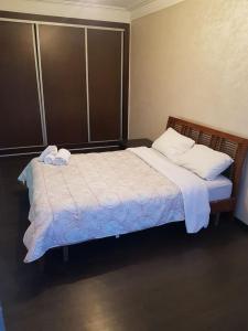 une chambre avec un grand lit avec des draps et des oreillers blancs dans l'établissement Franklin, à Casablanca