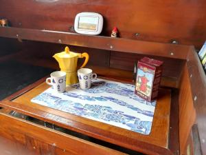 a table with a tea pot and two cups on it at Margarethe in Marina di Pisa
