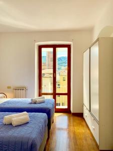 a bedroom with two beds and a large window at PRIONE173 City Center in La Spezia