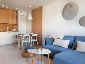 salon z niebieską kanapą i stołem w obiekcie CHILLIapartamenty - Bliżej Morza - HYGGE w Kołobrzegu