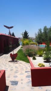 een tuin met een rode stoel in het midden bij Dar Tifrouine in Lalla Takerkoust