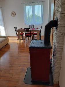 a wood stove in a living room with a table at Apartman Igy in Vinkuran