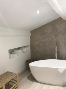 un bagno con una grande vasca bianca in una stanza di Antichambre a Nîmes