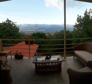 a balcony with a table and a view of the mountains at Omsi House in Tʼelavi