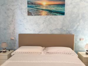 1 dormitorio con 1 cama con una pintura en la pared en Carluccio’s stanza privata vista mare en Furore