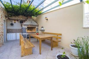 patio con mesa, bancos y horno al aire libre en Villa Marina Bol, en Bol