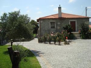 ein Steinhaus mit Blumen davor in der Unterkunft Quinta do Sobrado in Braga