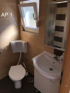 a bathroom with a white toilet and a sink at Apartments Zora in Rogoznica