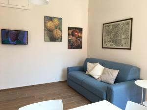 salon z niebieską kanapą i obrazami na ścianie w obiekcie A Casa di Clara w Syrakuzach