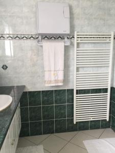 La salle de bains est pourvue d'un sèche-serviettes et d'un lavabo. dans l'établissement Chambres d'hôtes Chez Coco, à Saint-Georges-de-Reneins