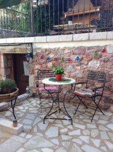 una mesa y sillas en un patio de piedra en Proselinos, en Dhimitsana