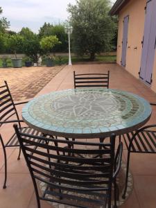 a patio table with chairs and a mosaic top at Chambres d'hôtes Chez Coco in Saint-Georges-de-Reneins