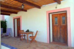 Casa con mesa, sillas y puerta de madera en Dammusi Eleonora, en Kamma