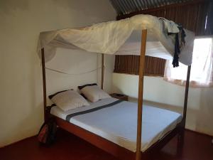 a bedroom with a bunk bed with a canopy at Les HIBISCUS in Ambondrona