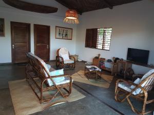 salon z fotelami bujanymi i telewizorem w obiekcie Les HIBISCUS w mieście Ambondrona