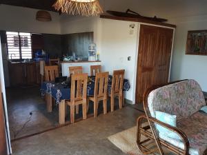 ein Esszimmer und eine Küche mit einem Tisch und Stühlen in der Unterkunft Les HIBISCUS in Ambondrona