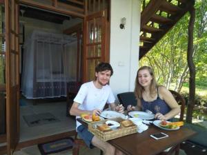 een man en een vrouw aan een tafel met eten bij Milkyway Holiday Resort in Unawatuna