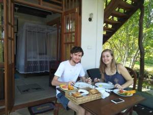 Ein Mann und eine Frau sitzen an einem Tisch mit Essen in der Unterkunft Milkyway Holiday Resort in Unawatuna + 19 Fotos