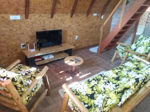 an overhead view of a living room with two chairs and a tv at Recanto Mauá - Chalé Azaleia in Visconde De Maua