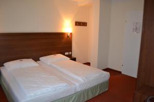 um quarto com 2 camas e uma cabeceira em madeira em PLAZA INN Salzburg City em Salzburgo