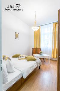 sypialnia z 2 łóżkami i stołem w obiekcie J&J Apartments Szeroka 25 Apartament 1 w Toruniu