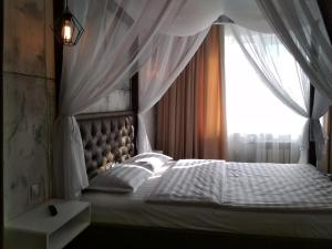 een slaapkamer met een wit bed met een raam bij LOFT - Interior design apartments in Oral