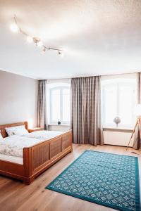 ein Schlafzimmer mit einem großen Bett und einem blauen Teppich in der Unterkunft Ferienwohnung Stadtplatz 25 in Traunstein