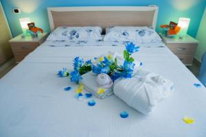 アルバ・アドリアティカにあるAppartamenti Abruzzo Rabelのベッドルーム1室(青い花とタオルのベッド1台付)