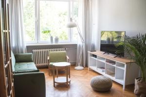 a living room with a tv and a chair and a table at TS City Centre Apartment in Szczecin