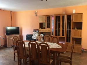 a dining room with a table and chairs and a television at La Teo in Măru