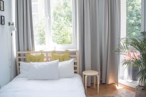 a bedroom with a bed with white pillows and a window at TS City Centre Apartment in Szczecin