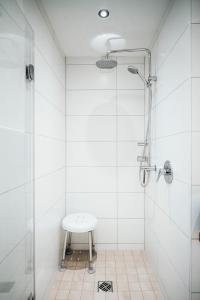 a white bathroom with a shower and a sink at Ferienwohnung Stadtplatz 25 in Traunstein