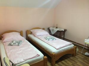 two twin beds in a room with a table at La Teo in Măru