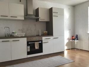 a kitchen with white cabinets and a stove at Ferienwohnung Elina in Maxhütte-Haidhof