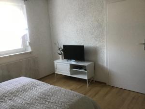 um quarto com uma cama e uma televisão num armário em Ferienwohnung Elina em Maxhütte-Haidhof
