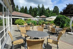 a patio with tables and chairs on a patio at Fletcher Hotel Restaurant Victoria-Hoenderloo in Hoenderloo