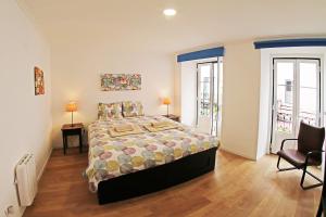 a bedroom with a large bed and two windows at RomanticHome at Alfama's Heart in Lisbon