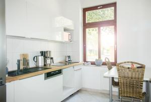 een witte keuken met een aanrecht en een raam bij Apartment Dora in Chemnitz