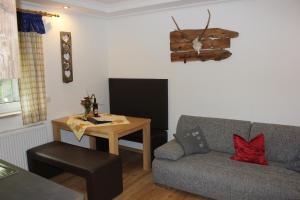 ein Wohnzimmer mit einem Sofa und einem Tisch in der Unterkunft Ferienwohnung Lasshofer in Sankt Michael im Lungau
