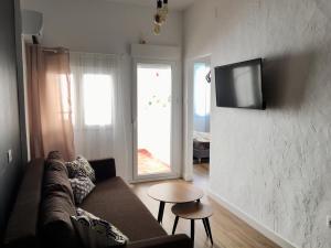 ein Wohnzimmer mit einem Sofa und einem TV an der Wand in der Unterkunft Ladrillo, apartment by the sea, Santa Pola in Santa Pola