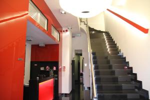 a staircase in a building with red walls and black stairs at Hotel Grey in Luxembourg