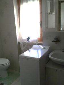 baño con aseo y lavabo y ventana en Residence ELIOS, en Caramanico Terme