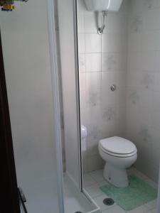 y baño blanco con aseo y ducha. en Residence ELIOS, en Caramanico Terme