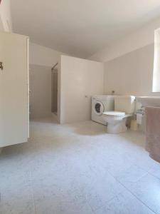 a white bathroom with a toilet and a sink at Villa Badde rosa in Dorgali